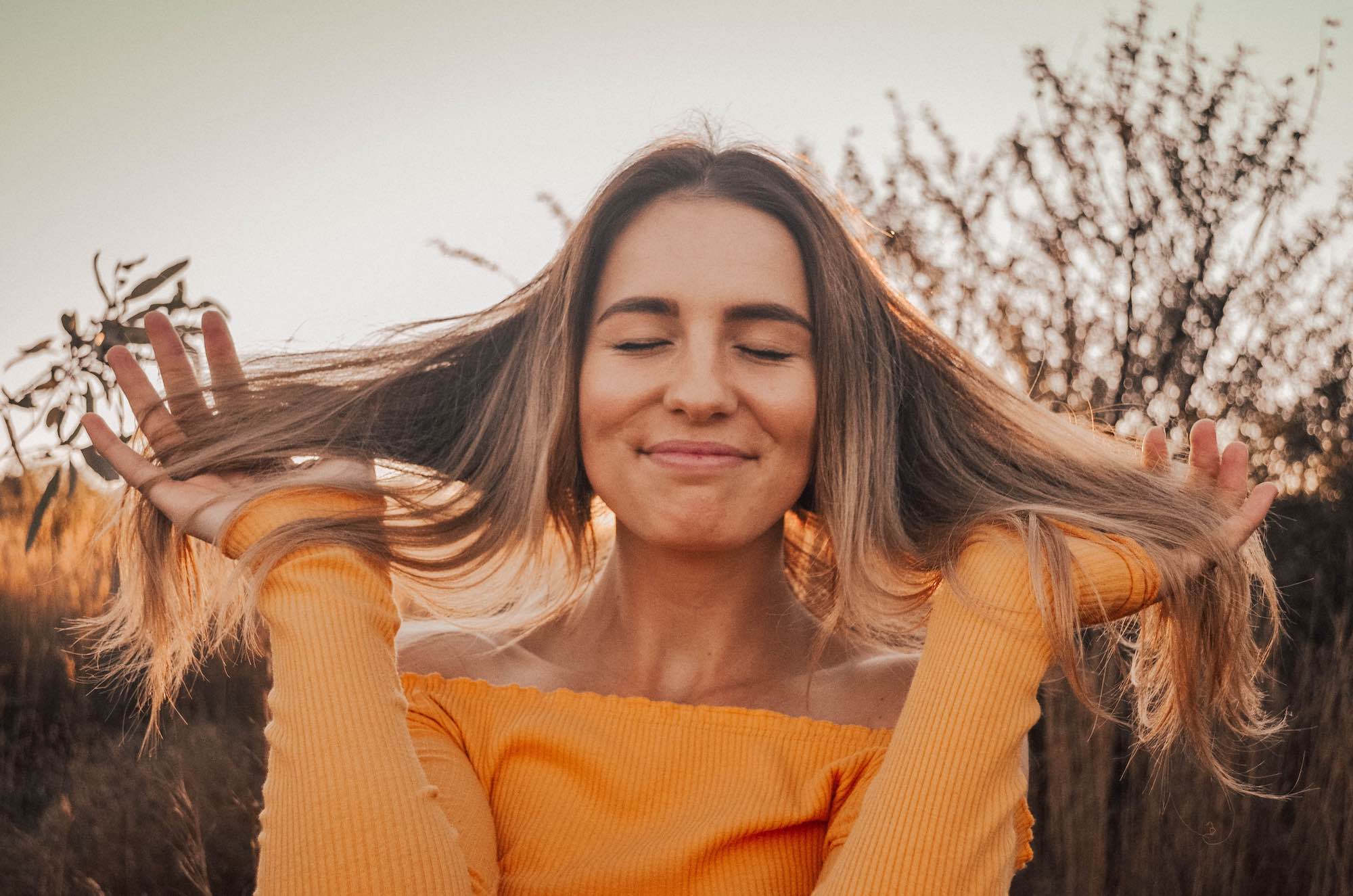 girl smiling with hands through her hair