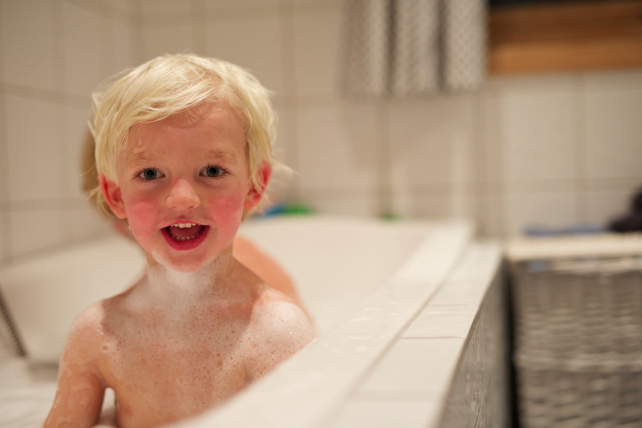 little blonde hair boy taking a bath