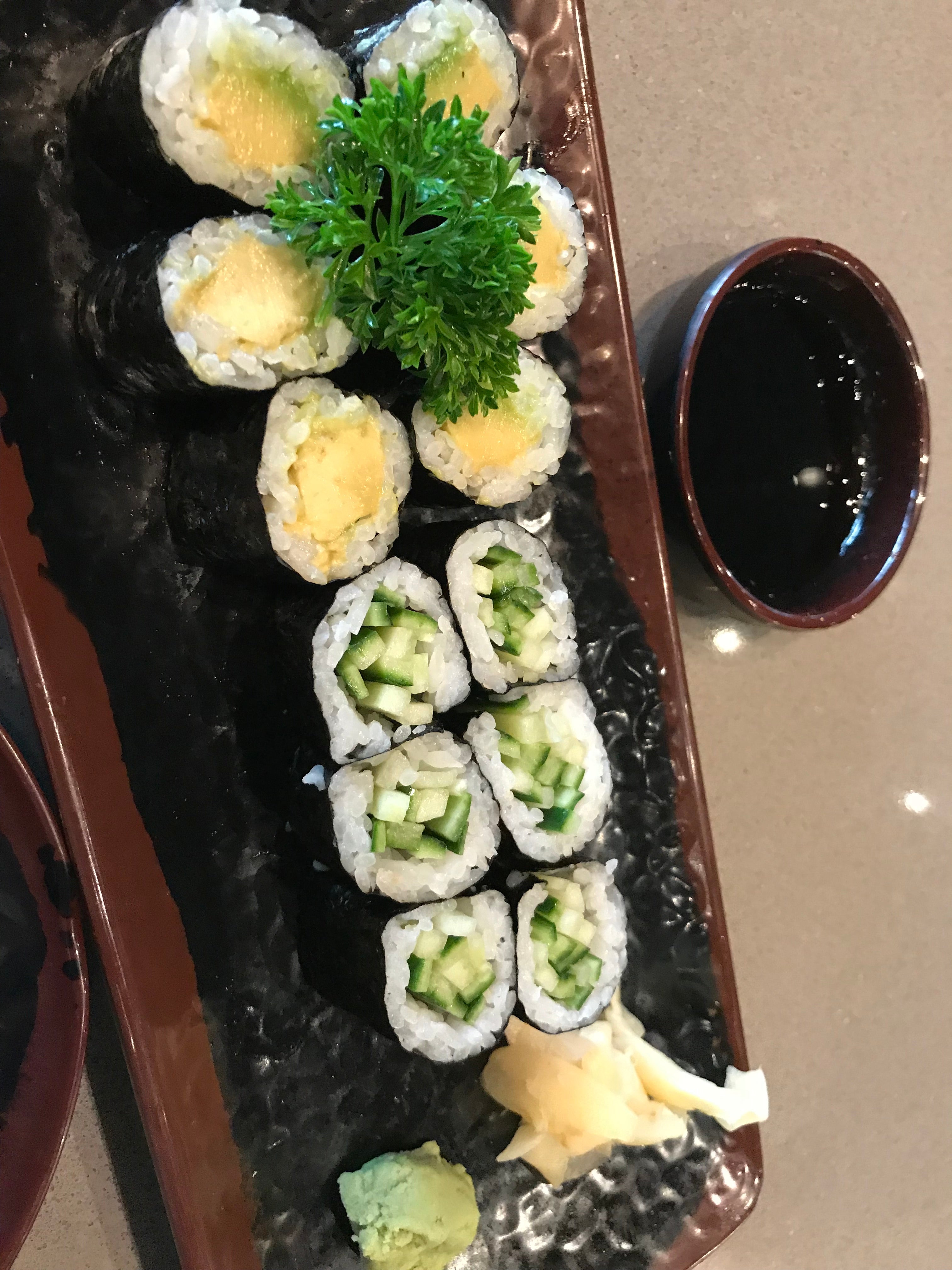 a variety of sushi and a side of soy sauce