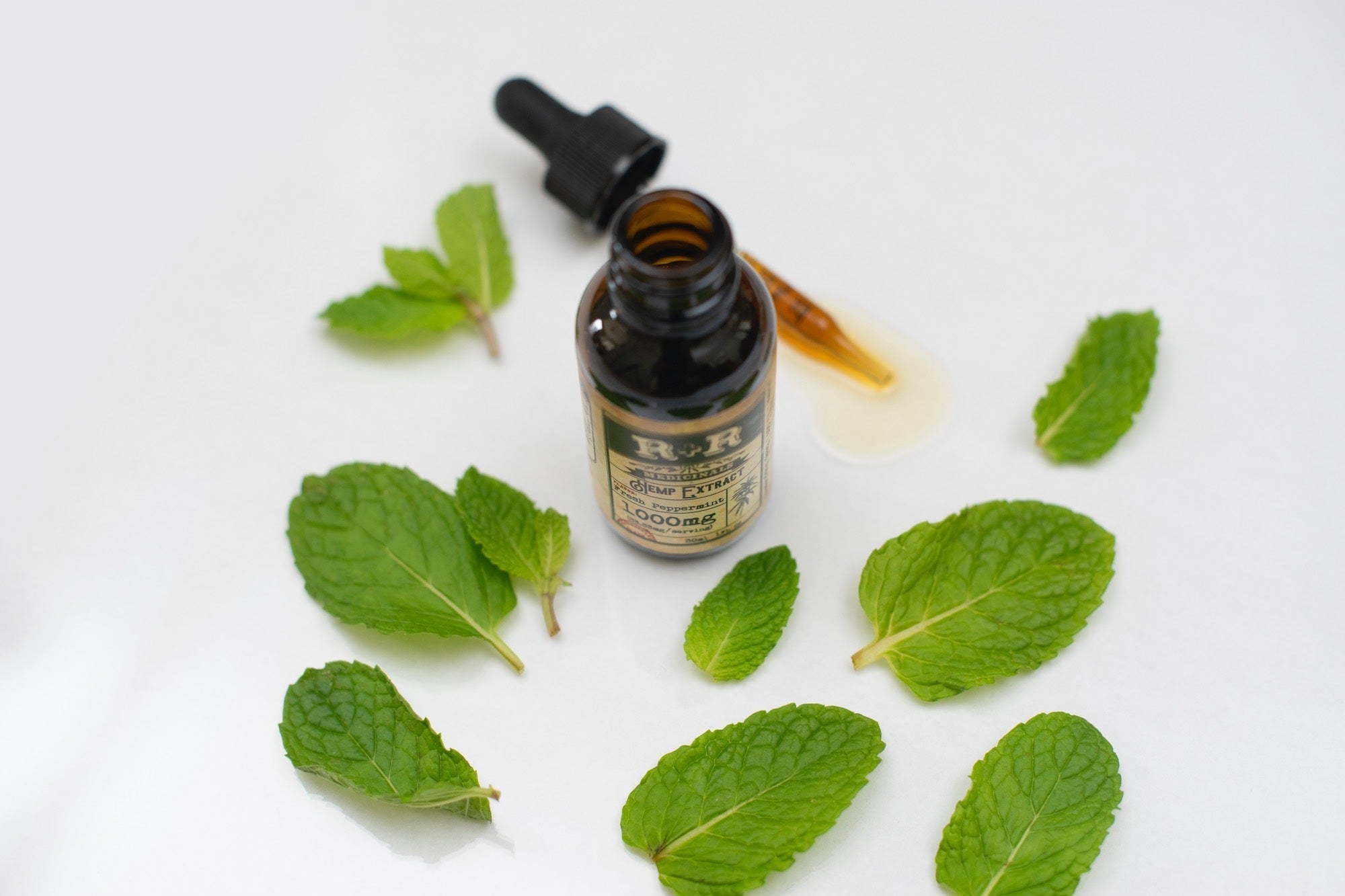 bottle surrounded with green mint leaves
