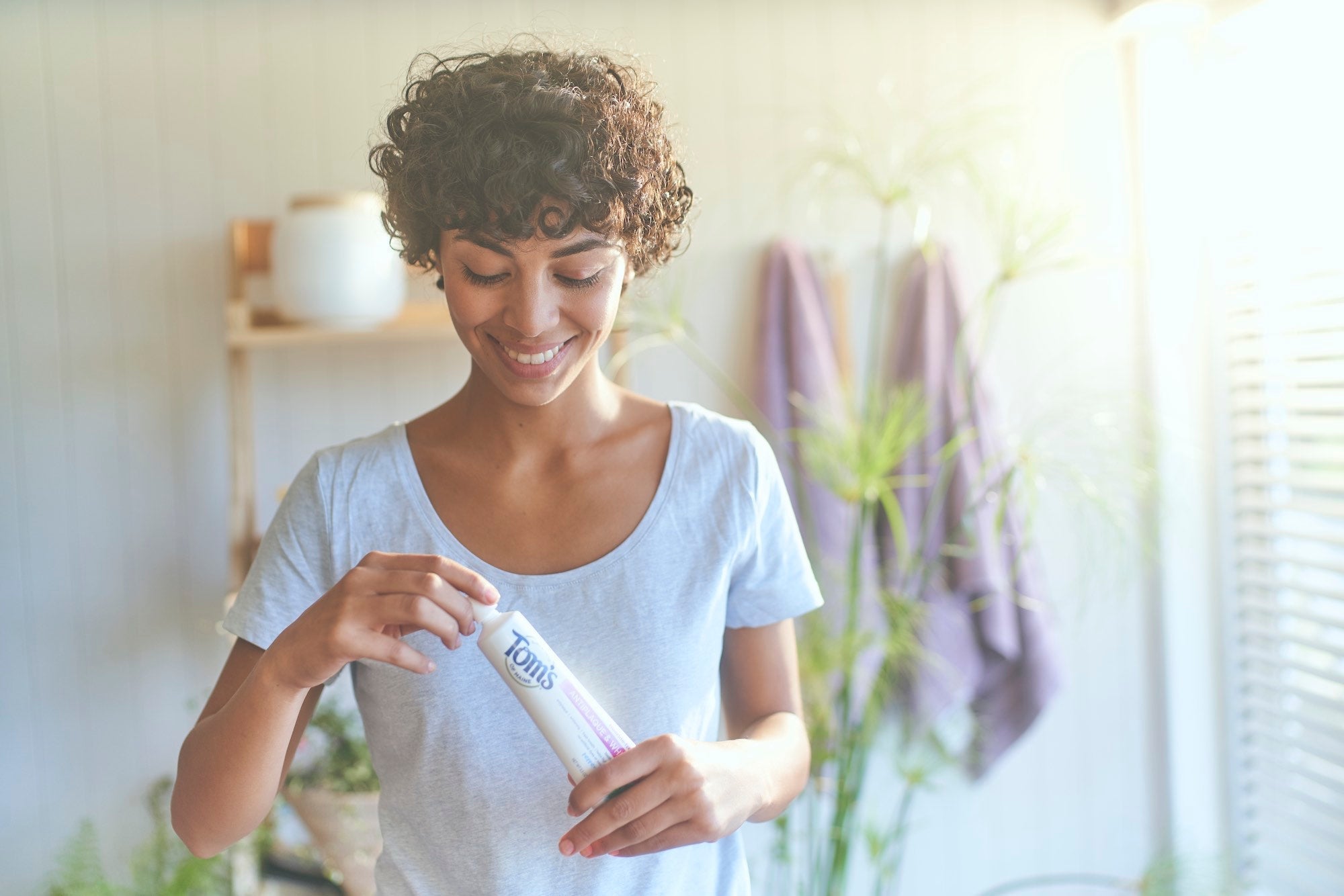 woman holding a Toms of Maine toothpaste tube