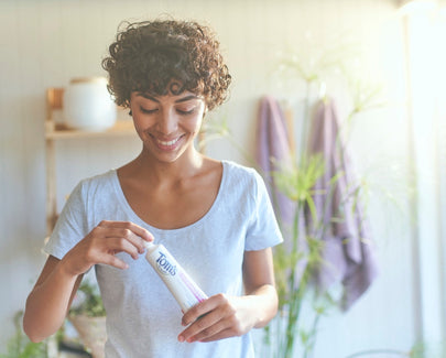 woman holding a Toms of Maine toothpaste tube