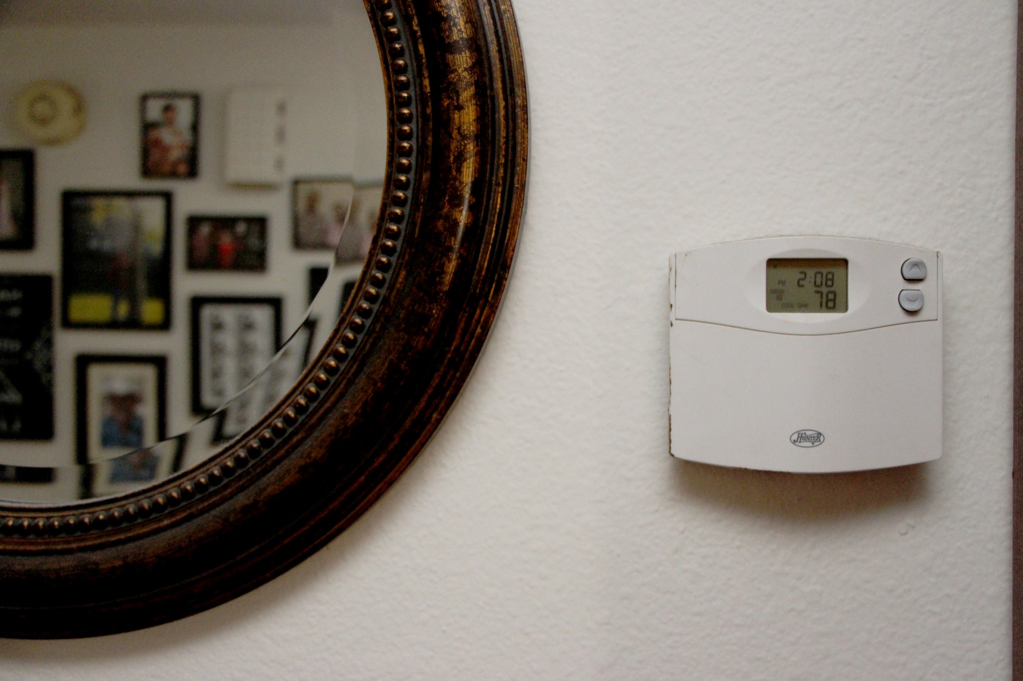 a Thermostat on a wall next to a mirror
