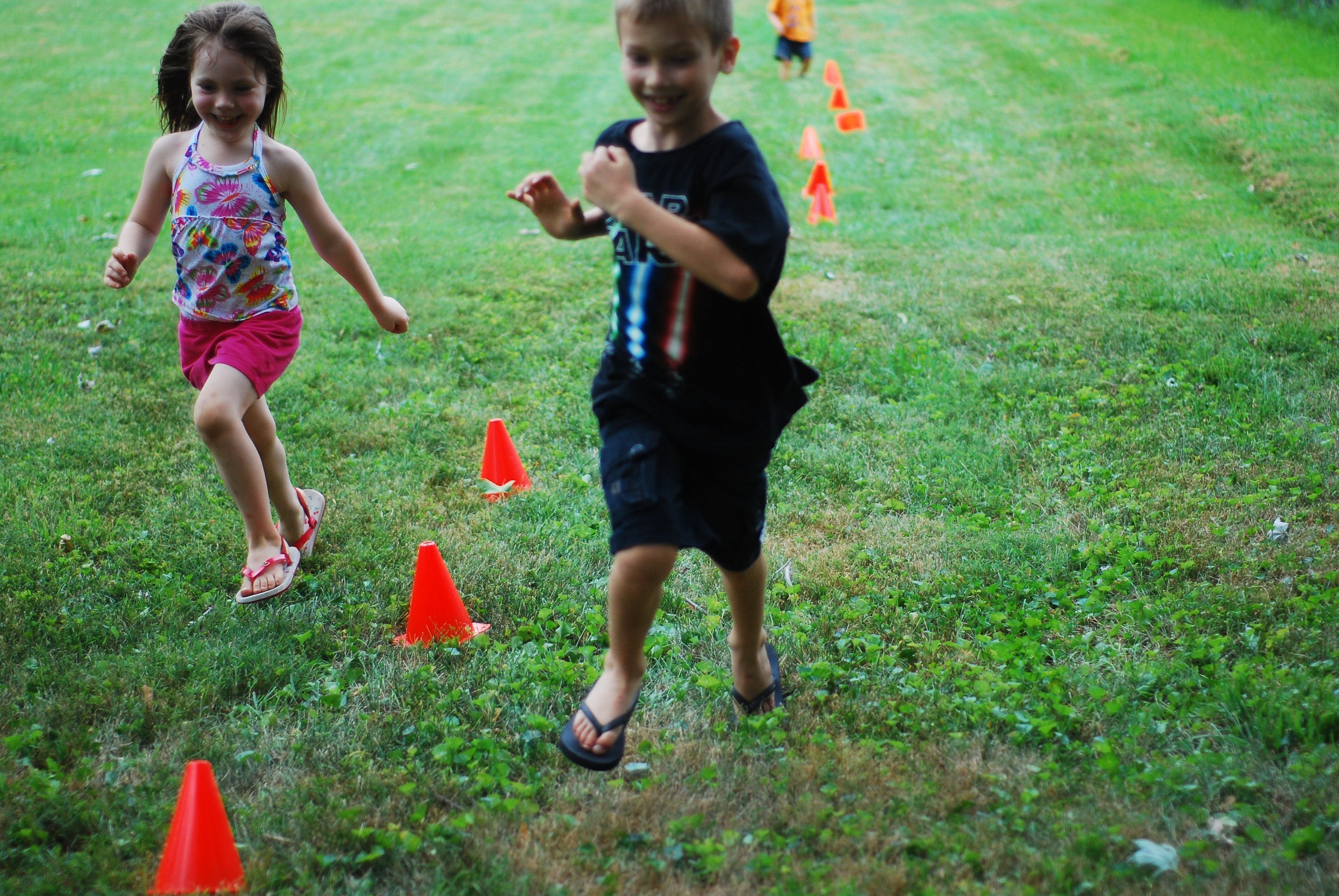 young kids running through obstacle cones