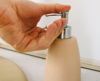 Hand Using a Liquid Soap Dispenser
