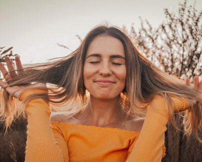 girl smiling with hands through her hair