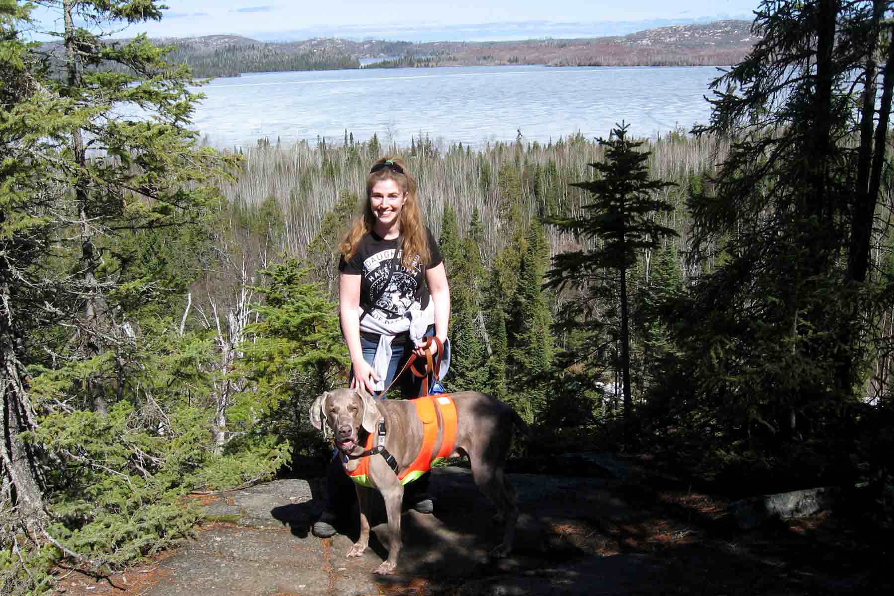 a woman hiking in the mountains with a dog