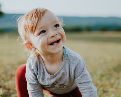 photo of baby crawling on grass