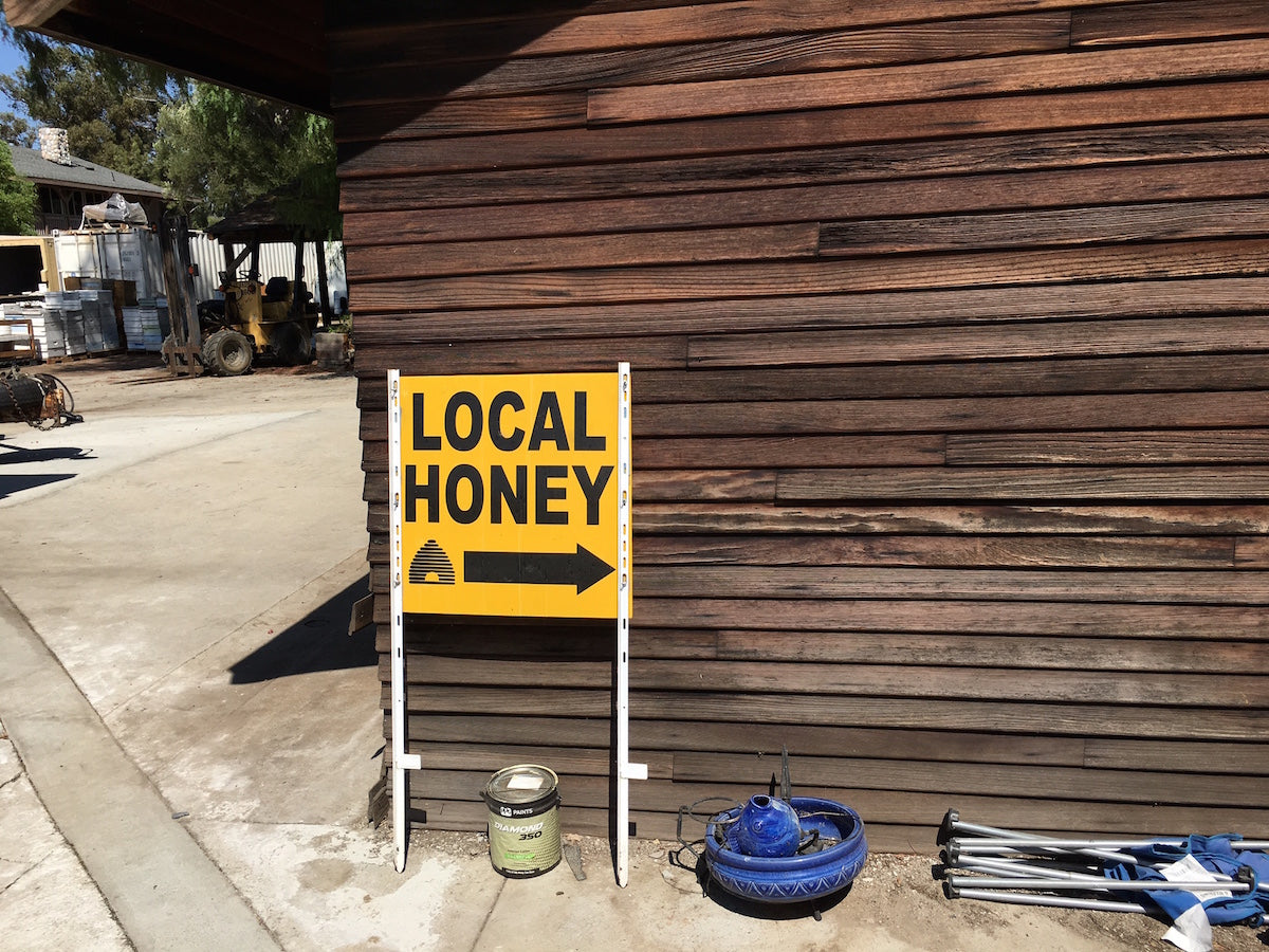 A sign that says Local Honey with an arrow pointing in the direction