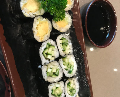 a variety of sushi and a side of soy sauce