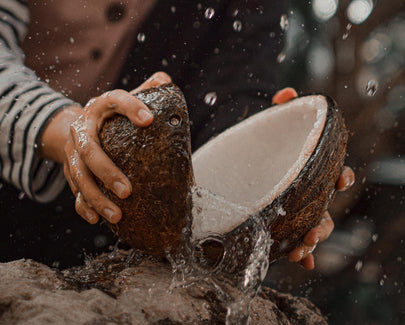Person breaking open coconut water