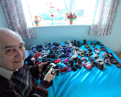 a man organizing socks on bed