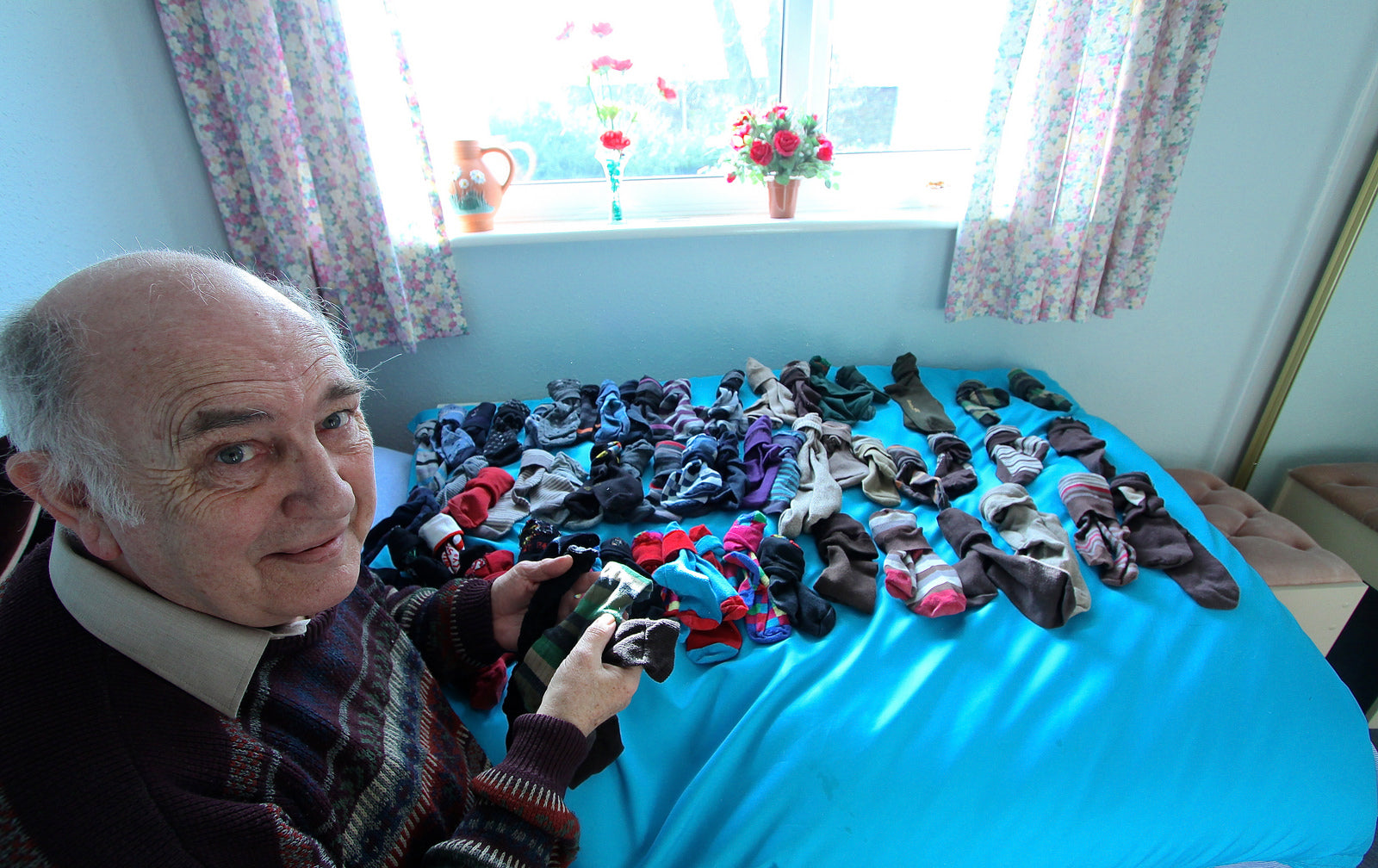 a man organizing socks on bed