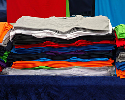a number of colorful t-shirts folded