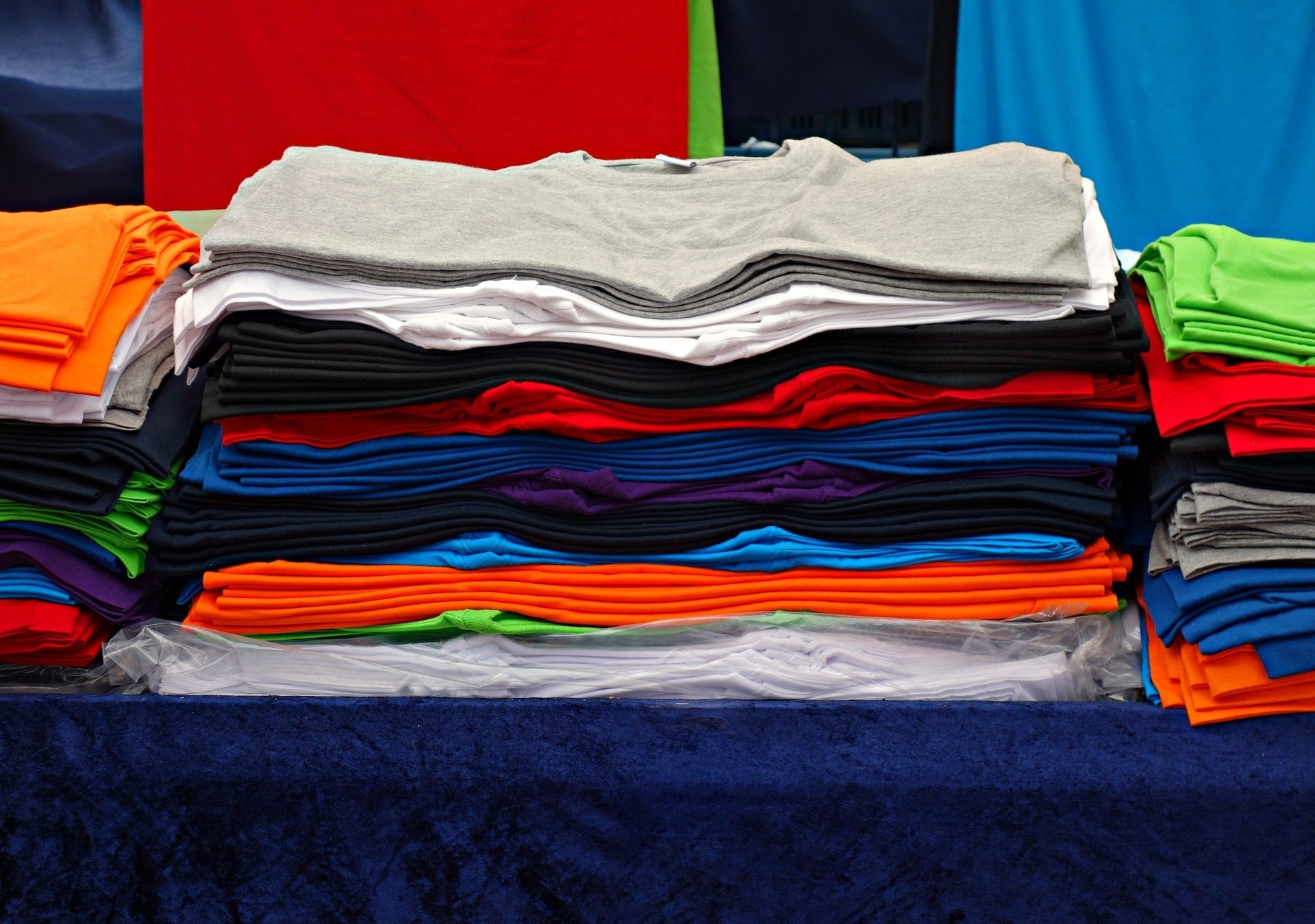 a number of colorful t-shirts folded